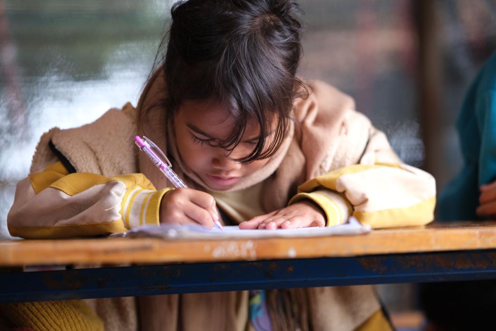 Bureau d'enfant avec cahiers et lumière studieuse, illustrant la construction précoce du perfectionnisme dans des environnements où la performance conditionnait l'approbation.