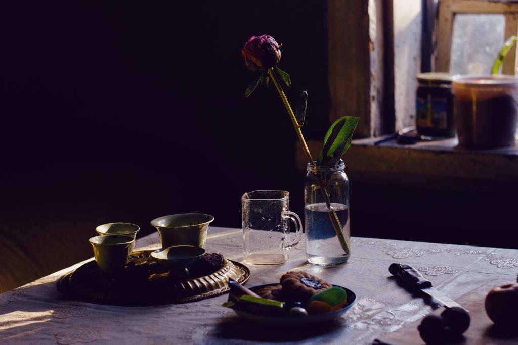 Détails imparfaits et beaux du quotidien — fleurs légèrement fanées, tasse ancienne — illustrant la beauté et la normalité de l'imperfection comme espace de respiration intérieure.