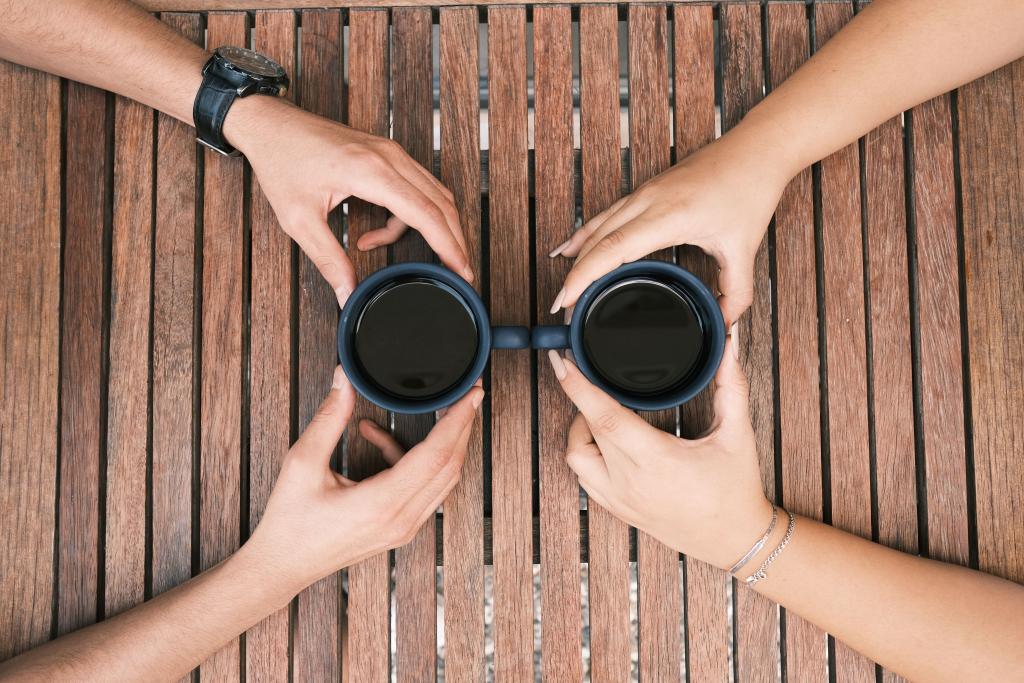 Deux tasses posées à distance sur une table en bois dans une lumière chaude, illustrant la notion de limite comme espace respectueux entre deux personnes.