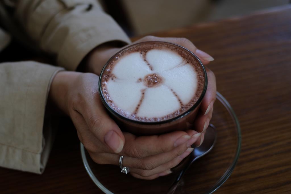 Mains tenant une tasse chaude, évoquant l'ancrage et la bienveillance envers soi-même dans la reconstruction de l'estime de soi.