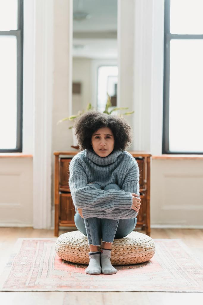 Femme assise, posture repliée, illustrant les tensions corporelles liées au stress émotionnel