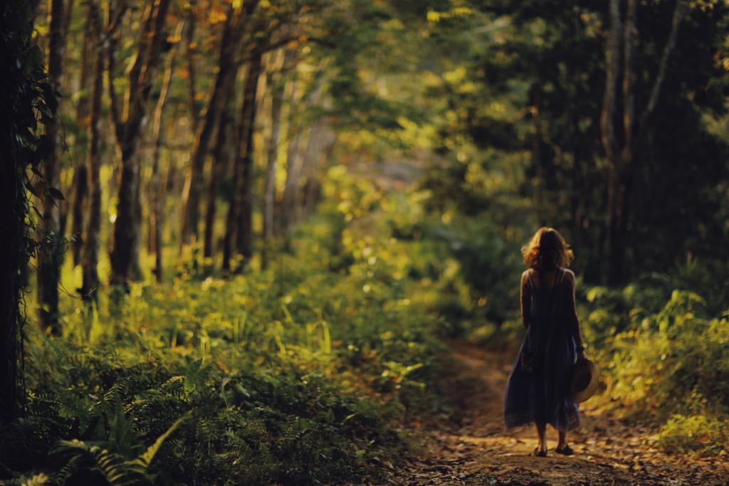 Femme marchant seule dans un espace naturel lumineux, évoquant le retour à soi par le mouvement et la présence au corps — thérapie par la marche.